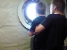 Justus and David peering out a portal window